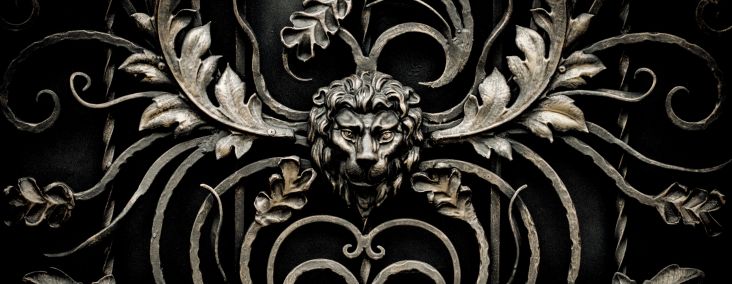 Ornate ironwork featuring a lion's head amidst scroll designs, provided by Fairway Divorce Solutions.