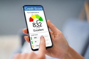 Hands holding phone with a credit score app.