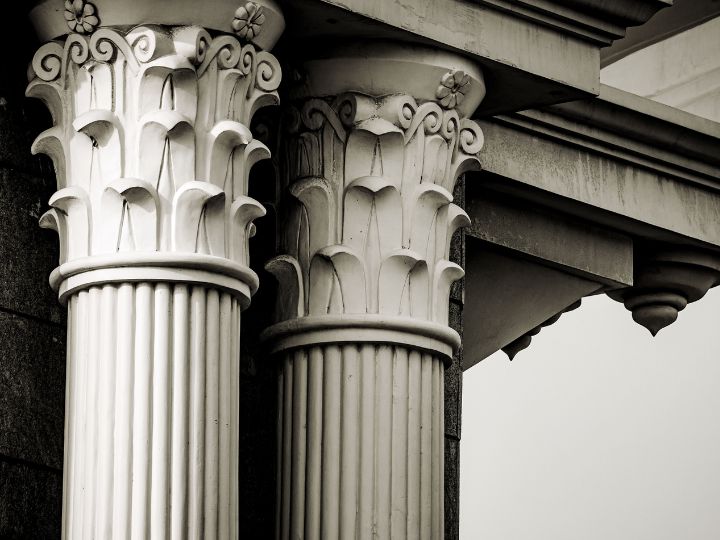 Close-up of classical architectural columns with Corinthian capitals, reminiscent of the stability and structure that Fairway Divorce Solutions aim to provide during divorce mediation.