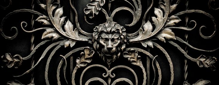 Ornate ironwork featuring a lion's head amidst scroll designs, provided by Fairway Divorce Solutions. 